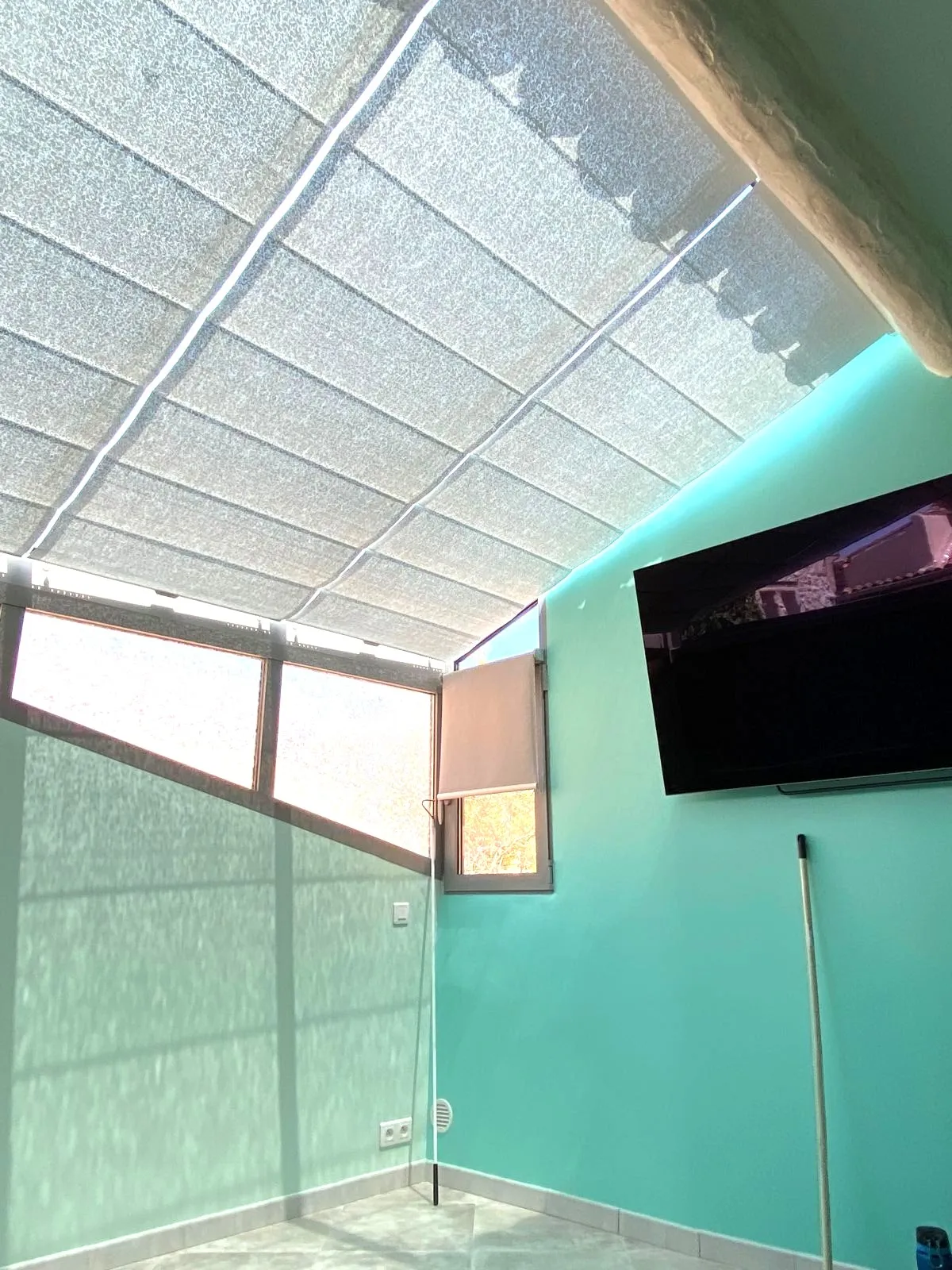 Store de toiture microperforé installé dans une véranda trapèze