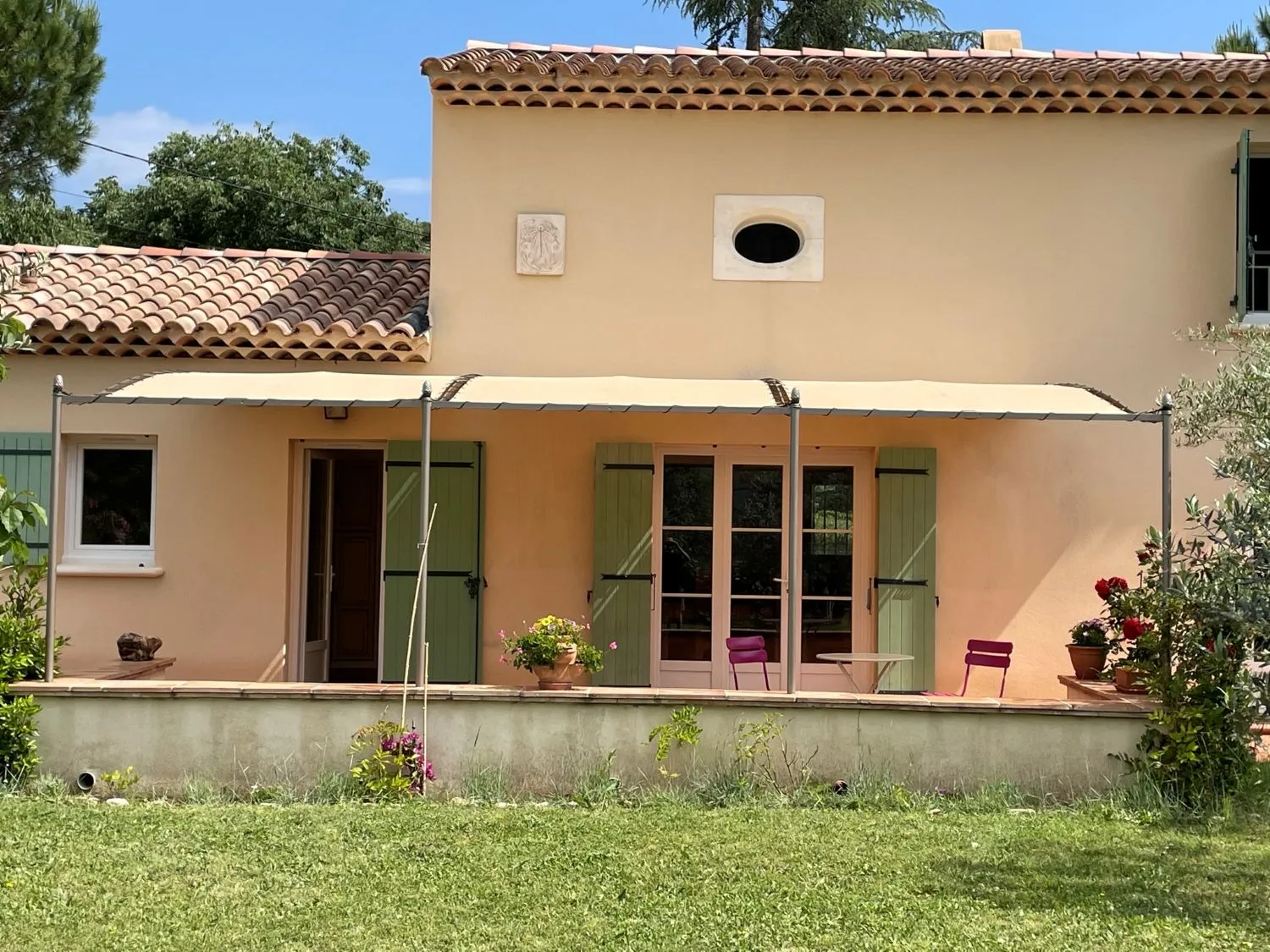 Terrasse avec toile tendue sur pergola fer forgé