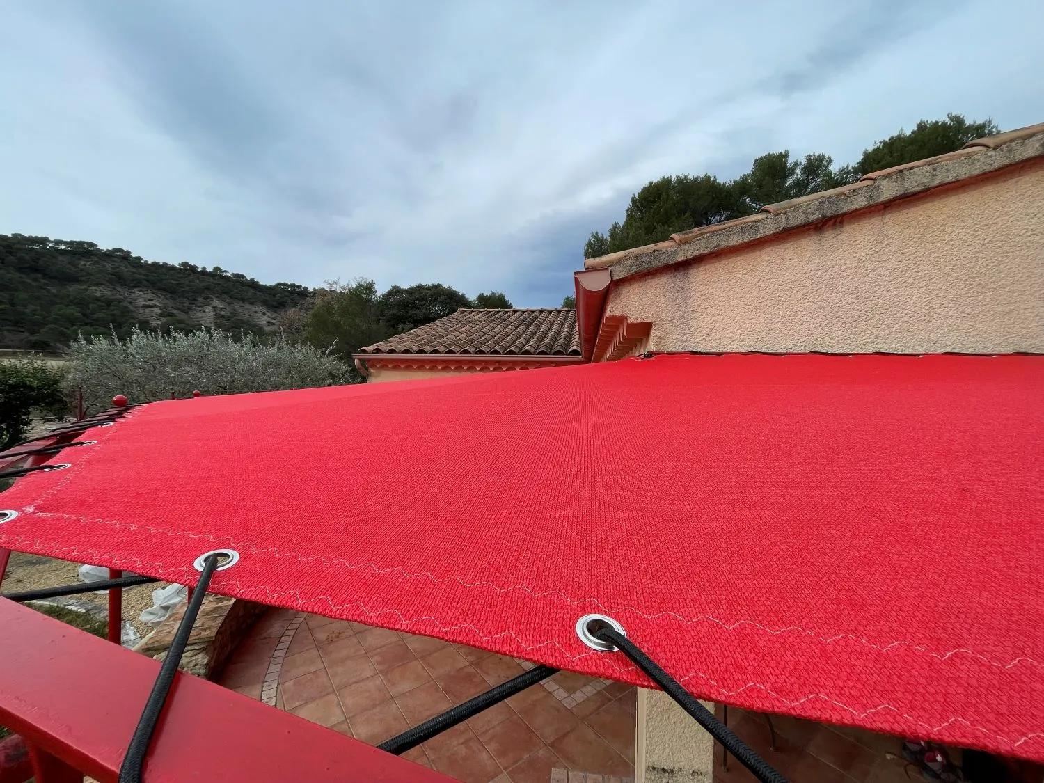 Fixation sandow et œillets inox sur toile de pergola